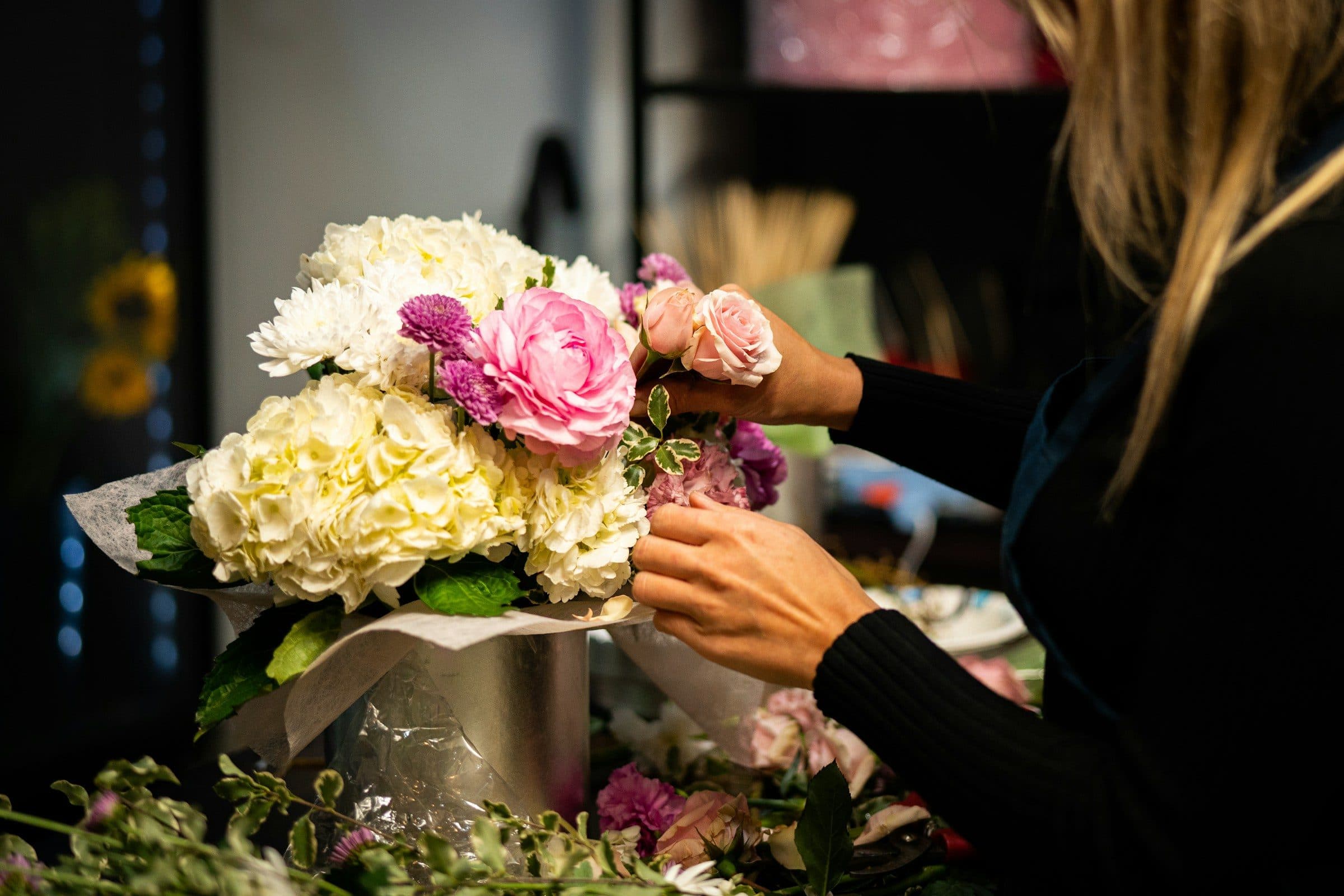 A florist arranging a bouquet in her shop